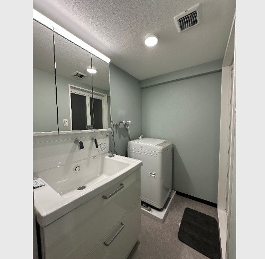 洗面所の壁紙を薄い水色のクロスを採用されました。落ち着きのあるおしゃれな空間になりました。